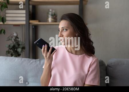 Young happy attractive arabic woman using virtual assistant application. Stock Photo