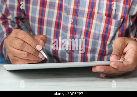young man with pen using digital tablet on table  Stock Photo