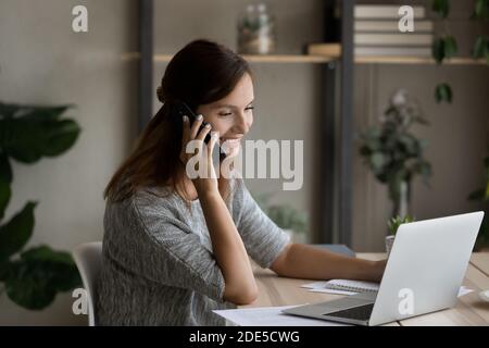 Smiling young businesswoman holding mobile call conversation. Stock Photo