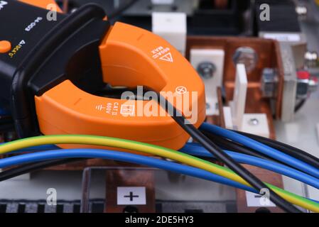 Clamp meter measure current on cable on power supply devices Stock Photo