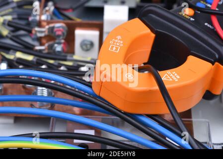 Clamp meter measure current on cable on power supply devices Stock Photo