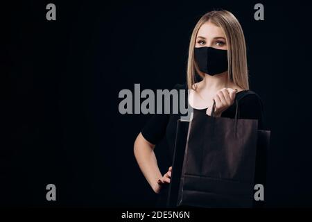 Woman in mask posing with shopping bags Stock Photo