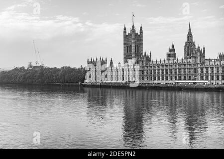 Black and white Houses of Parliament, the iconic London building and tourist attraction with River Thames, shot in Coronavirus Covid-19 lockdown in England, UK
