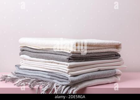 A stack of rolled blankets, sheets, and towels on the table. Stock Photo