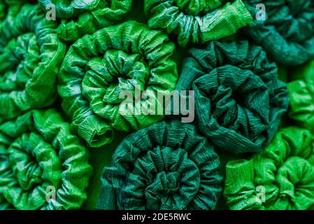 Abstract green pattern, background. Ornament from fabric with curls, twisted tubes. Stock Photo