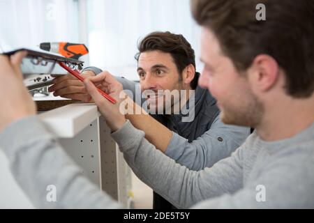 two men installing new kitchen hob Stock Photo