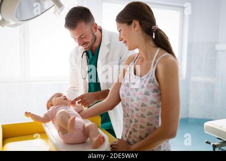 Doctor pediatrician with mother and baby child in clinic. Hospital, examining, child concept.