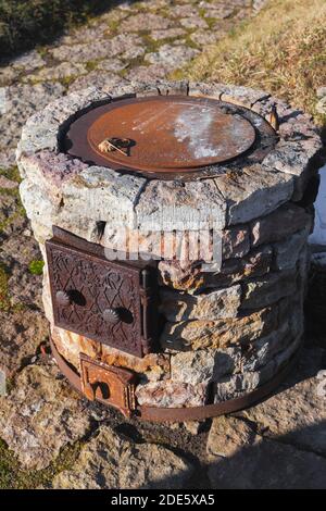Vintage outdoor stone stove is used to outdoor cooking on the fire Stock Photo