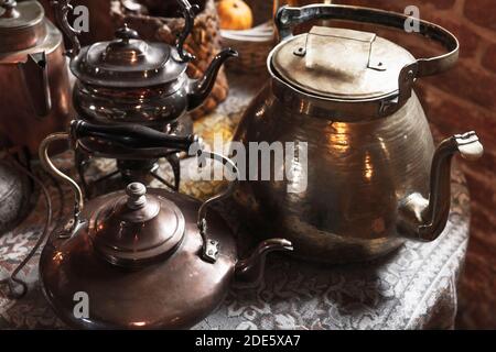 Vintage copper teapots are on a table, close-up photo with selective soft focus Stock Photo
