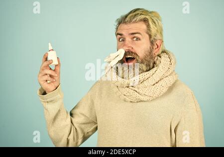 free your stuffy nose. no addiction to medicals. coronavirus from china. happy hipster presenting best remedy. Nasal drops plastic bottle. pandemic concept. man treat runny nose with nasal spray. Stock Photo