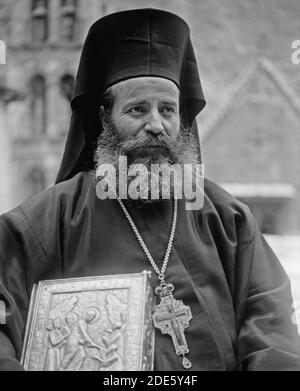 Middle East History - Greek Orthodox priest at St. Catherine's Monastery in the Sinai holding prized manuscript with silver cover from their library Stock Photo