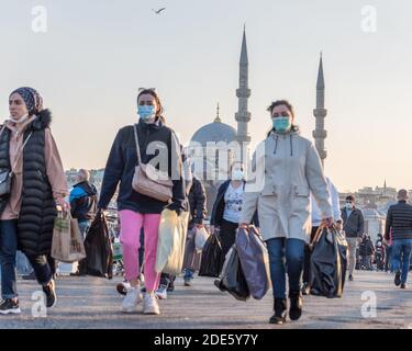 Unidentified Turkish people wearing protective face masks walking at Galata bridge during coronavirus COVID-19 epidemic.Istanbul,Turkey.16 November 20 Stock Photo