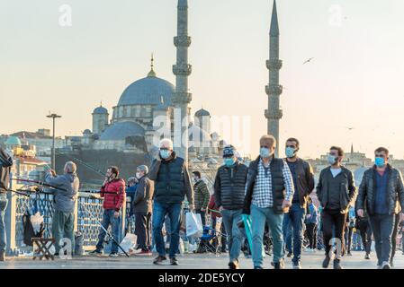 Unidentified Turkish people wearing protective face masks walking at Galata bridge during coronavirus COVID-19 epidemic.Istanbul,Turkey.16 November 20 Stock Photo