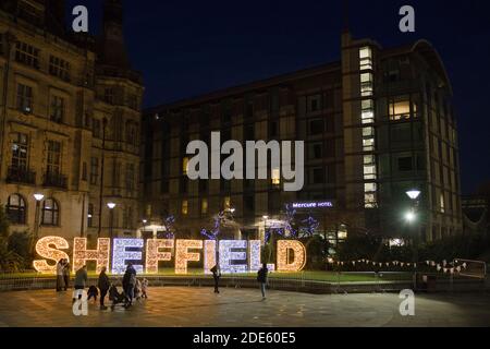 Sheffield, United Kingdom, 27th November, 2020: People taking photos with and enjoying the illuminated sheffield city center christmas lights of 2020 Stock Photo