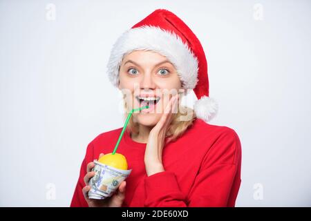 Symbol of wealth and richness. Girl with lemon and money. Lemon money concept. Girl santa hat drink juice lemon wrapped in banknote. Totally natural lemon juice. Fresh lemonade drink with straw. Stock Photo