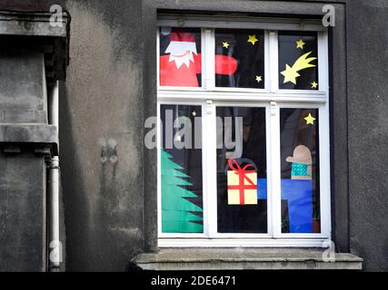 Dortmund, Germany, November 29th, 2020: Nikolaus with the Amazon logo as his mouth delivers the package, the giving man wears mouth and nose protection against the virus. Apartment window decorated for Christmas indicates Christmas Eve in Corona times. Stock Photo