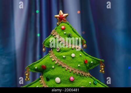 Christmas tree on a blue background. Decorative spruce made of fabric, decorated with buttons. New year concept. Festive mood. Stock Photo