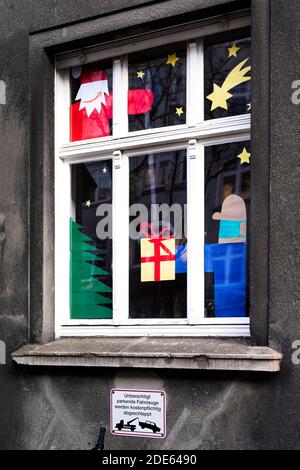 Dortmund, Germany, November 29th, 2020: Nikolaus with the Amazon logo as his mouth delivers the package, the giving man wears mouth and nose protection against the virus. Apartment window decorated for Christmas indicates Christmas Eve in Corona times. Stock Photo