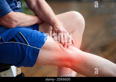 Unrecognizable elderly man having knee pain. Stock Photo