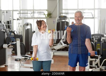 Senior caucasian couple exercising using dumbbells. Stock Photo