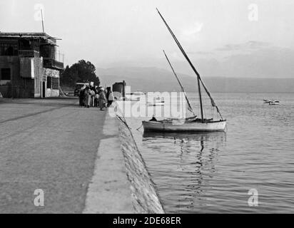 Original Caption:  Tiberias sea front (with white sail boat)  - Location: Israel--Tiberias ca.  1934-1939 Stock Photo