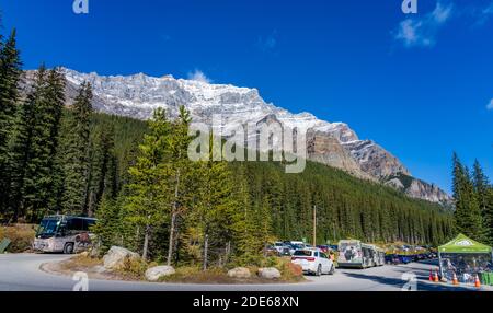 Moraine Lake Car Parking Area in summer sunny day. Bus and cars stop here. Stock Photo
