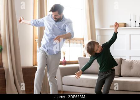 Excited young dad with little son dancing at home Stock Photo