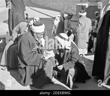 Middle East History - Sheik helping peasant to fill out ap[p]lication form for identity card Stock Photo