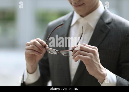 Close up of businessman holding eyeglasses Stock Photo