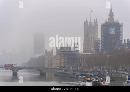 Foggy morning in London. Palace of Westminster, Parliament, on a grim, dull day. Elizabeth Tower, Big Ben, shrouded in scaffolding for renovation Stock Photo