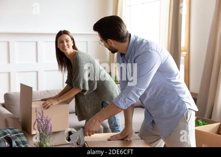 Happy couple packing seal boxes with tape Stock Photo