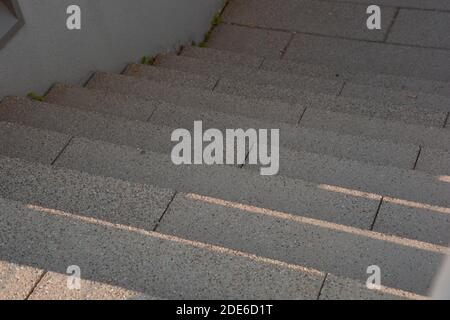 red granite stairs steps background looking downstairs with light reflections on it Stock Photo