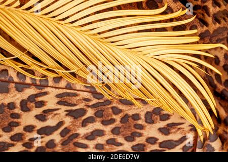 Branch of tropical palm tree and on background of exotic pattern of leopard, jaguar, rainforest backdrop Stock Photo