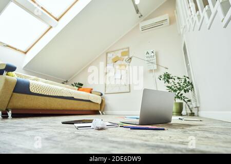 Elearning concept. Laptop, digital tablet, notebook and other school supplies on the wooden floor in the living room at home Stock Photo