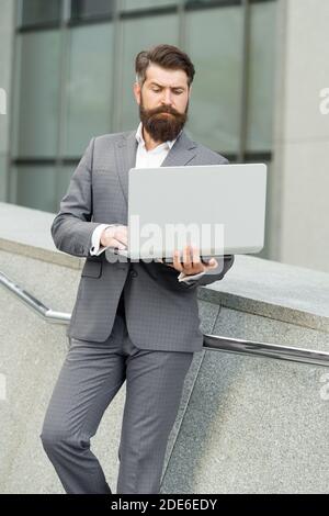 Computer communication network. Bearded man use computer outdoors. Business communication. Making video call. E-mail mail and messaging. Internet surfing. 3G. 4G. Modern technology. Stock Photo