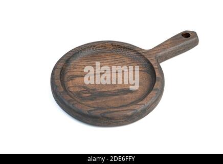Wooden round cutting Board made of oak material with a handle, painted in a dark color, isolated on a white background. Stock Photo