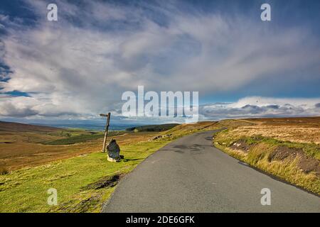 Image of a Public Bridleway Sign and a Country Road, Stainmore near Kirkby Stephen, Cumbria, England, UK. Stock Photo