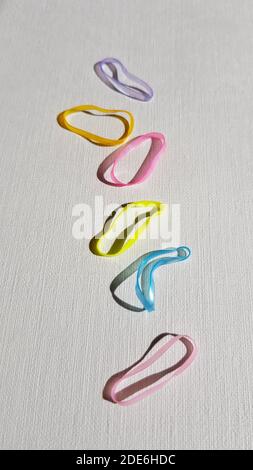 Set of small elastic bands for hair on a white table. Stock Photo