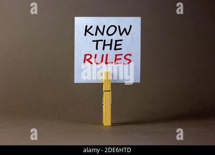 Time to know the rules. White paper with text 'know the rules', clip on wood clothespin. Beautiful grey background. Business and know the rules concep Stock Photo