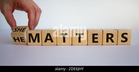 All gender matters. Hand turns a cube and changes the words 'he matters' to 'she matters'. Beautiful white background. Concept. Copy space. Stock Photo