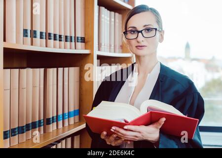 Lawyer working on a difficult case reading in the library Stock Photo