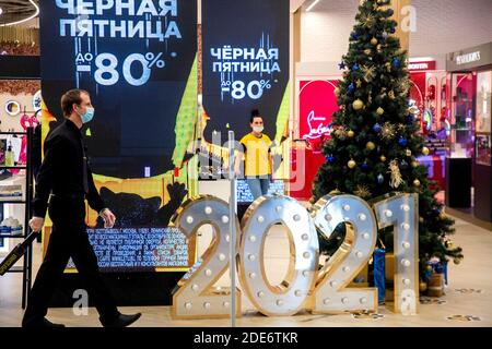 Moscow, Russia. 29th of November, 2020 employees perfume shop wearing face mask in the Aviapark shopping mall on the Black Friday sales days during the novel coronavirus COVID-19 pandemic in Russia. The posters read 'Black Friday'. The term Black Friday was coined in the United States in the 1960s; it refers to the Friday following Thanksgiving Day celebrated in the US on the fourth Thursday of November. Being the biggest shopping event of the year, Black Friday opens the Christmas shopping season Stock Photo