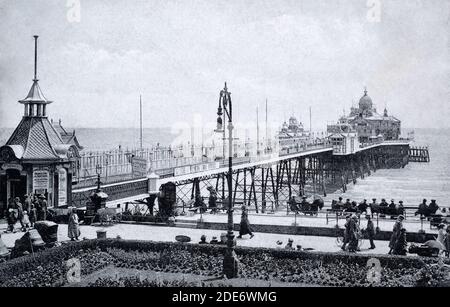 A historical view of Eastbourne pier and people in Eastbourne, Sussex, England, UK. Taken from a postcard c. early 1900s.