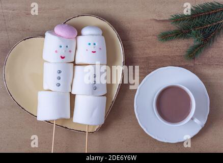 Cute marshmallow snowmen on the heart shaped plate Stock Photo