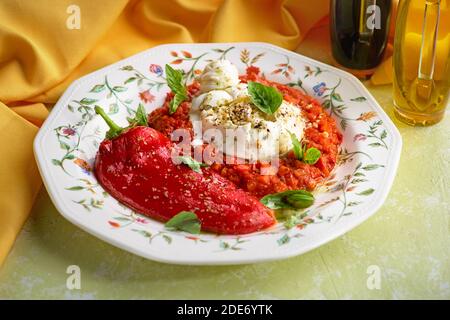 Fresh italian cheese burrata with baked peppers and vegetable saute Stock Photo