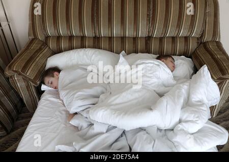 Two brothers sleeping in bed in the morning Stock Photo