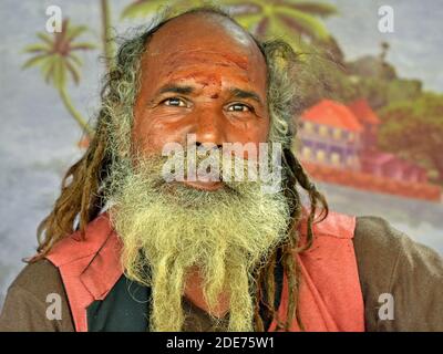 Elderly Indian Hindu Shaivite sadhu with rasta-style dreadlocks and beard poses for the camera during the Shivratri Mela (Bhavnath Fair). Stock Photo