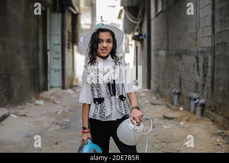 Slim girl wears elegant skirt posing with shy smile. Outdoor portrait of  winsome lady with long hai Stock Photo by look_studio