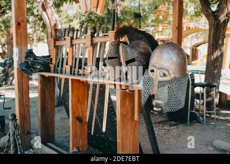 Exhibition of Medieval knightly armor in ancient fortress. Swords, shields and other weapons. Stock Photo