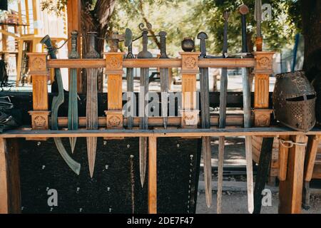 Exhibition of Medieval knightly armor in ancient fortress. Swords, shields and other weapons. Stock Photo